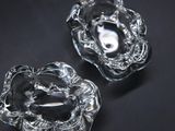 two clear glass dishes on a black surface