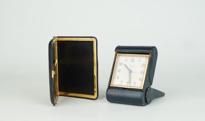 une petite horloge posée à côté d'une autre petite horloge sur une table