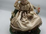 figurine en porcelaine représentant une femme assise sur une chaise avec un panier de fleurs