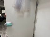un homme debout à côté d'un réfrigérateur blanc dans une pièce