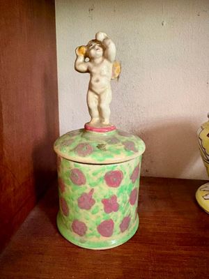 une petite figurine posée sur une boîte, elle-même posée sur une étagère