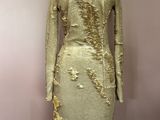 une robe de mannequin ornée de paillettes dorées, posée sur un mannequin