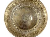 a gold plate that is sitting on a white surface