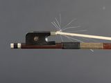 a bow with a stick sticking out of it on a gray background