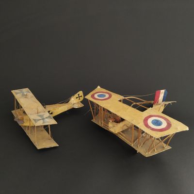 two wooden model airplanes sitting on a black surface