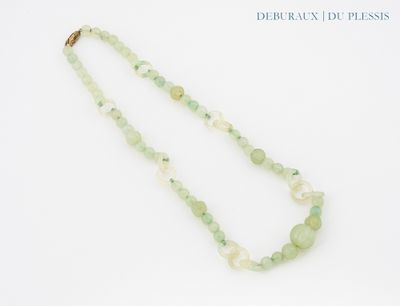 collier composé de perles vertes et blanches sur fond blanc