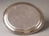 a silver plate on a table with a white background