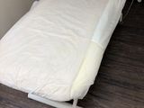a bed with a white sheet on it in a room