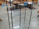 une table en verre sur laquelle sont posées trois étagères en verre