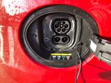 an image of a red car with an electric charger plugged into it