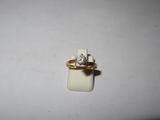 a gold ring with a diamond on it sitting on a white surface