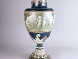 a blue vase with a picture of a group of people on it
