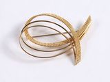 a close up of a gold brooch with a knot on it