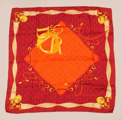 une écharpe orange et dorée ornée d'un motif monogrammé