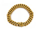 gros plan d'un bracelet en chaîne en or sur fond blanc