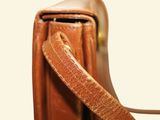 a close up of a brown leather bag with a handle