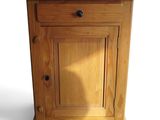 a small wooden cabinet with a drawer on top of it