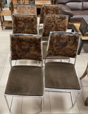 Plusieurs chaises sont alignées dans une pièce où se trouvent un canapé et une table basse