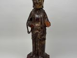 une statue en bois représentant une personne portant un chapeau sur la tête