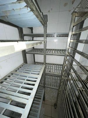 many racks of food in a kitchen that is dirty