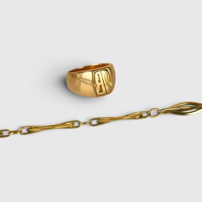 un gros plan d'une bague en or entourée d'une chaîne