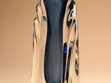 un vase en verre posé sur une table, sur fond marron