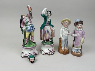 trois figurines représentant des personnes sont posées sur une table
