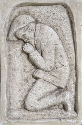 un gros plan sur la statue d'un homme assis à genoux