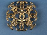 a close up of a gold brooch on a blue background