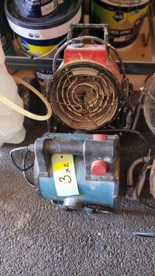 un petit ventilateur posé par terre à côté d'autres objets