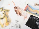 many different colored drawings on a table next to a cup of coffee