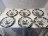 six plates with floral designs on them sitting on a table