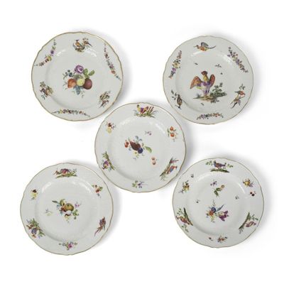quatre assiettes sur lesquelles sont peints des oiseaux et des fleurs sur un fond blanc