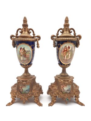 pair of antique vases sitting on pedestals on a white surface