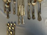a lot of silver spoons and forks on the table