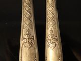 two silverware on a black table with a knife and a knife holder