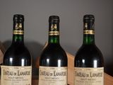 three bottles of wine are lined up on a wooden shelf