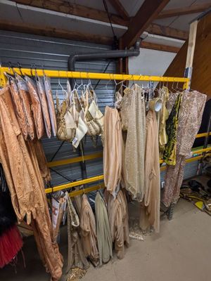 beaucoup de vêtements suspendus à une étagère dans une pièce