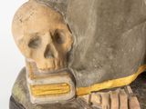 a statue of a man with a skull on his foot