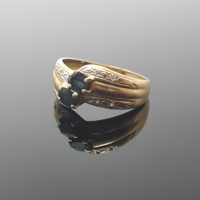 an image of a gold ring with a blue stone