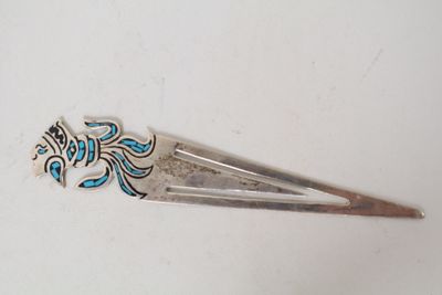 a silver hair clip with a blue and white design on it