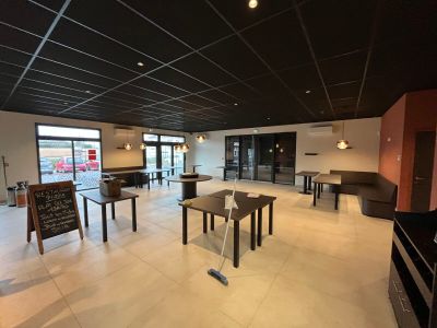 une pièce avec des tables et des chaises, et une affiche accrochée au mur