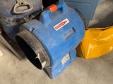 un aspirateur bleu et jaune posé à côté d'une poubelle