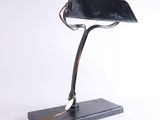 une image représentant une lampe de bureau noire sur fond blanc