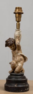 a statue of a cupid holding a candle on a table