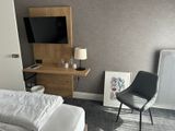 a bed and a chair in a room with a tv