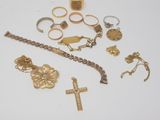 several different types of gold jewelry including a cross, bracelet, and ring