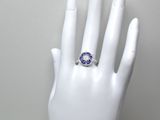une main blanche ornée d'une bague bleue et blanche