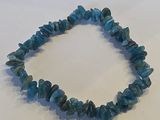 un gros plan d'un bracelet orné de perles bleues sur un fond blanc