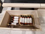 a wooden box filled with bottles of liquid sitting on the floor